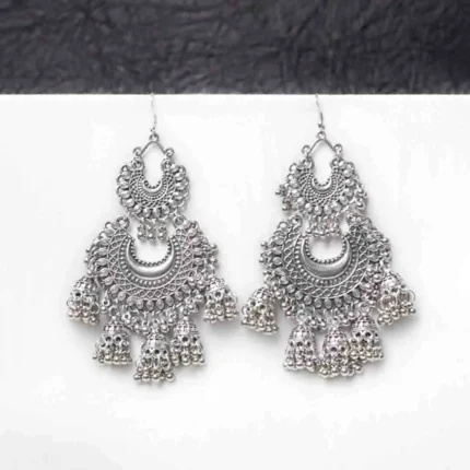 Fusion-style oxidised silver dangle earring featuring interconnected crescent elements, adorned with small jhumka-inspired details and ghungroos for a traditional touch, secured with a curved hook closure.