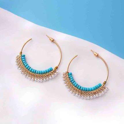Chic open-end hoop earrings in gold with aqua blue and pearl white hues, decorated with a row of turquoise cylindrical beads and a fringe of small white pearl-like beads, secured with a push back post