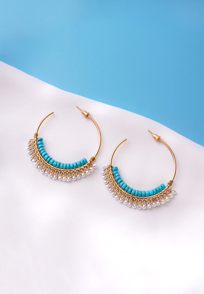 Chic open-end hoop earrings in gold with aqua blue and pearl white hues, decorated with a row of turquoise cylindrical beads and a fringe of small white pearl-like beads, secured with a push back post