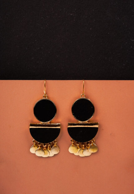 Unique handcrafted bohemian drop earring with a gold-tone frame, black wooden accents, a sleek gold bar, and shell charms, secured with a curved hook.