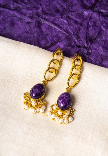 Elegant metal drop earrings in a polished gold, dark pink, and pearl white finish, showcasing overlapped oval links, a purple marble-textured stone, and delicate dangling pearls, finished with a push-back closure.