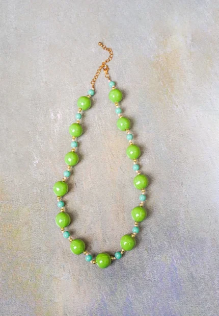 Colorful beaded necklace designed with round green beads and perfectly placed golden and sky-blue accents, secured with a lobster claw clasp