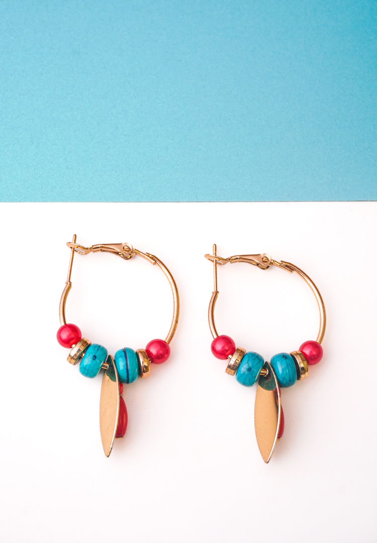 187-Th Chic metal hoop earrings featuring a polished gold-tone finish, playful enamel accents, and dangling golden and red charm ,a push back for easy wear.