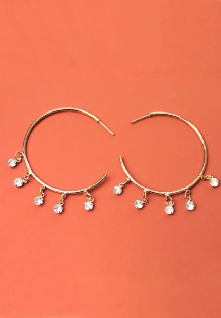 Trendy mini C-hoop earring with a polished gold-tone/pearl finish, adorned with a dangling clear gemstones and , push-back post.