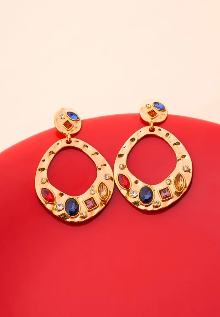Unique gold-tone drop earrings featuring irregular hammered circular discs, shimmering clear and colorful gemstone embellishments, and a secure push-back closure