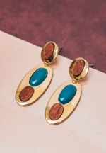 Eye-catching oval-shaped drop earrings with a luxe gold-tone finish, a deep teal stone at the center, and two organic wooden detailing, secured with a push-back post.