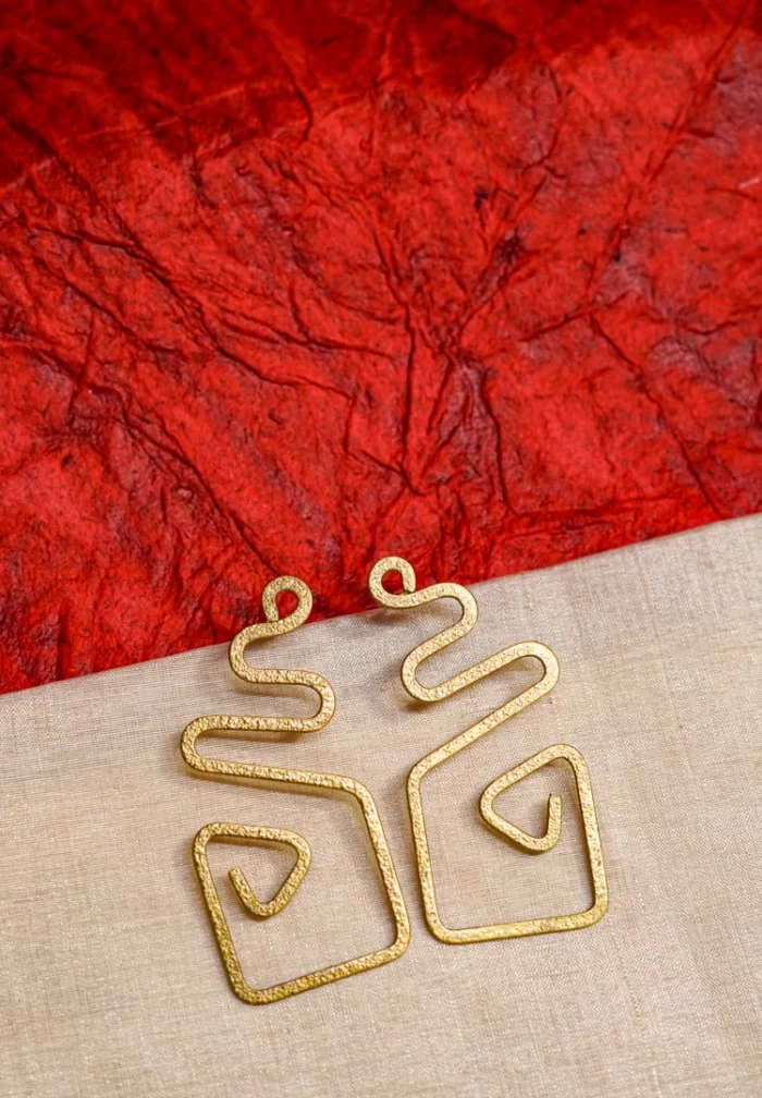Minimalist brass earrings with an irregular abstract design, subtle texture detailing, and a classic push-back closure.
