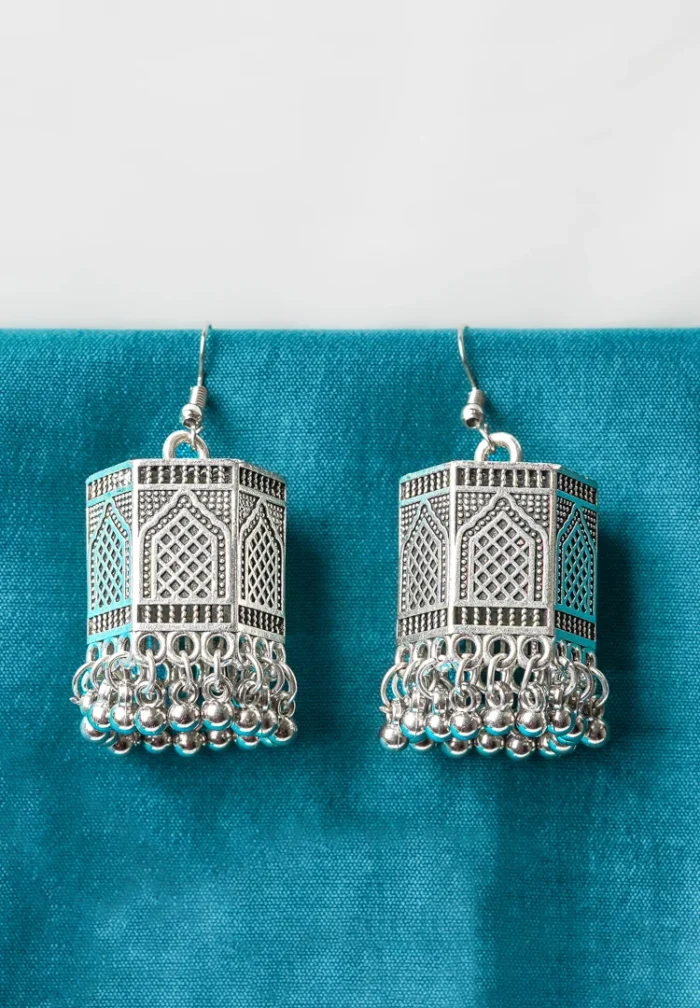 Stylish geometric metal dangle earrings with a silver finish along with colorful a hexagonal shaped jhumka, ghungroo at the end, and a push-back closure.