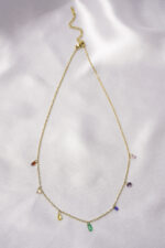 Elegant adjustable curb chain bracelet in a gold-tone finish, featuring a curved metallic wire centerpiece with a dangling spherical charm and a secure spring ring clasp