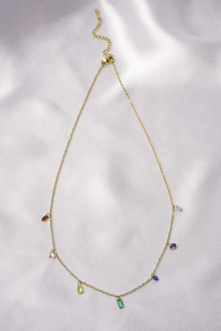 Elegant adjustable curb chain bracelet in a gold-tone finish, featuring a curved metallic wire centerpiece with a dangling spherical charm and a secure spring ring clasp