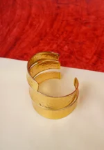 Elegant metal cuff bracelet showcasing teardrop and circular design at the edges, beautifully enhanced with a lively mix of vibrant colors.