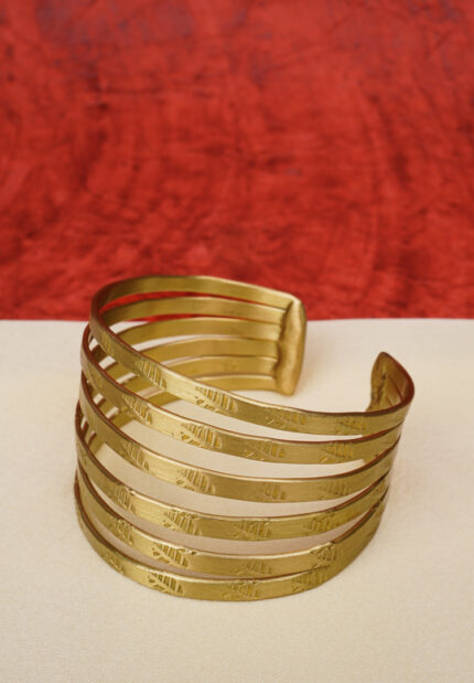 Elegant metal cuff bracelet showcasing teardrop and circular design at the edges, beautifully enhanced with a lively mix of vibrant colors