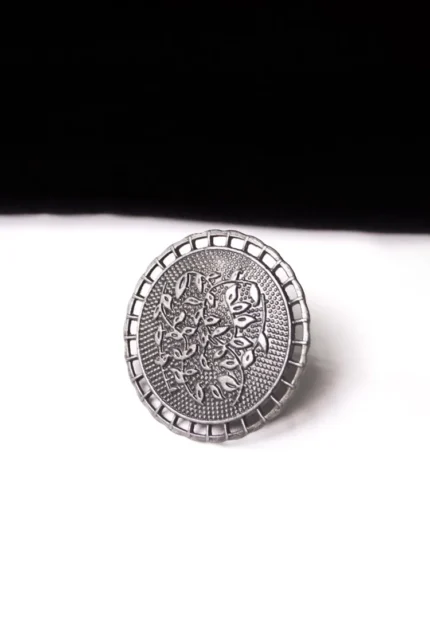 Artisan-crafted oxidized silver-tone statement ring with intricate floral embellishments and a prominent leafy design in the center