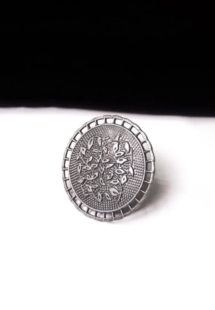 Artisan-crafted oxidized silver-tone statement ring with intricate floral embellishments and a prominent leafy design in the center