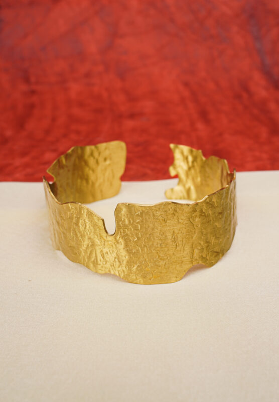 Elegant metal cuff bracelet showcasing teardrop and circular design at the edges, beautifully enhanced with a lively mix of vibrant colors.