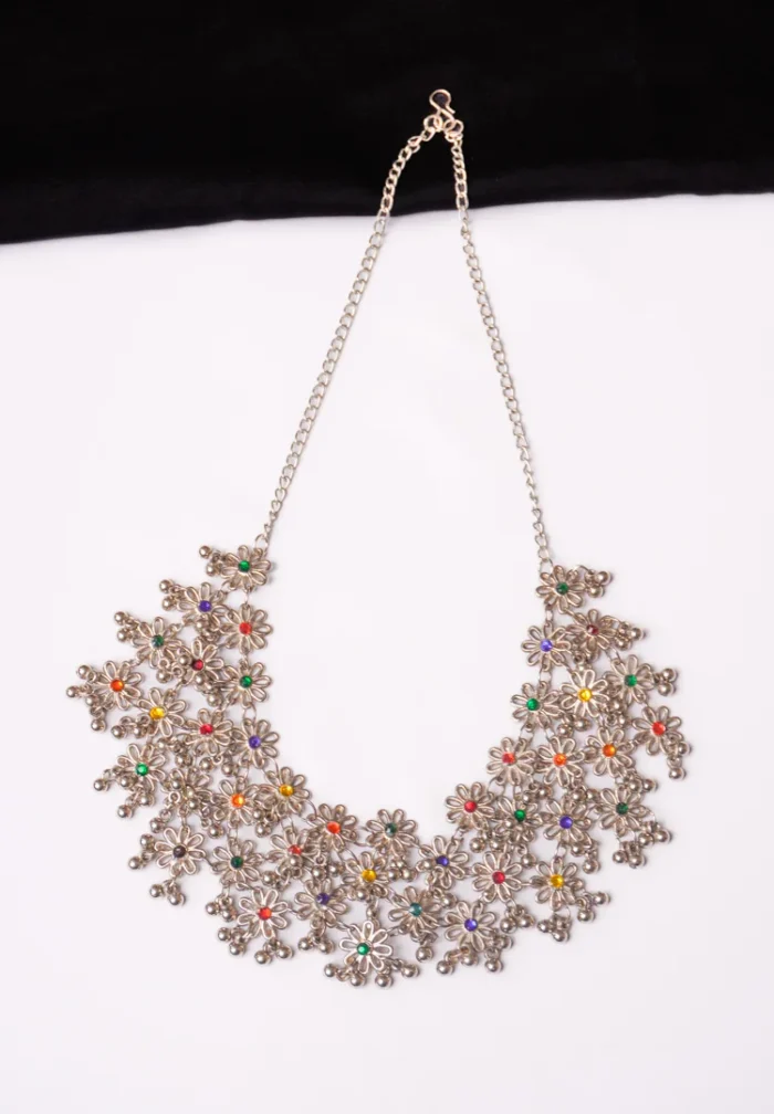 Timeless oxidized silver-tone curb chain necklace interconnected with small flower shaped designs adorned with colourful gemstones and and tiny ghungroos, finished with a sturdy S hook for a secure fit.