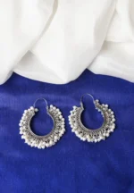 Classic oxidized silver hoop earring with an open-end design, detailed carvings, and dainty pearl beads, secured with a hinged back closure.