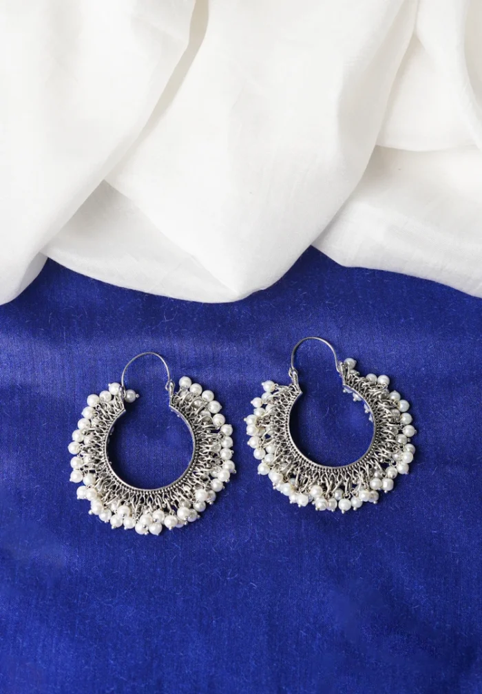 Classic oxidized silver hoop earring with an open-end design, detailed carvings, and dainty pearl beads, secured with a hinged back closure.