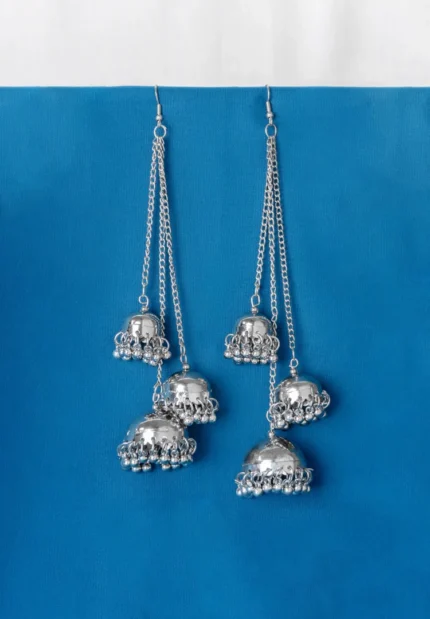 Statement silver tassel earrings featuring a delicately engraved design, long chain tassels for an elegant dangle effect with jhumkas and ghungroos at the end, and a curved hook feature
