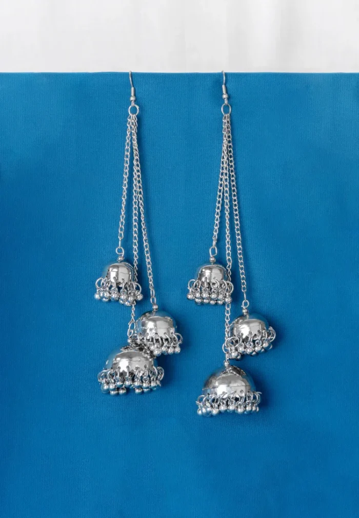 Statement silver tassel earrings featuring a delicately engraved design, long chain tassels for an elegant dangle effect with jhumkas and ghungroos at the end, and a curved hook feature