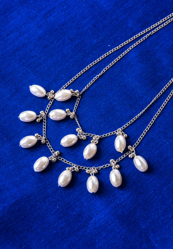 Chic double-layered curb chain necklace in a polished silver-tone finish, styled with oval pearls and small circular beads, complete with an S-hook closure.