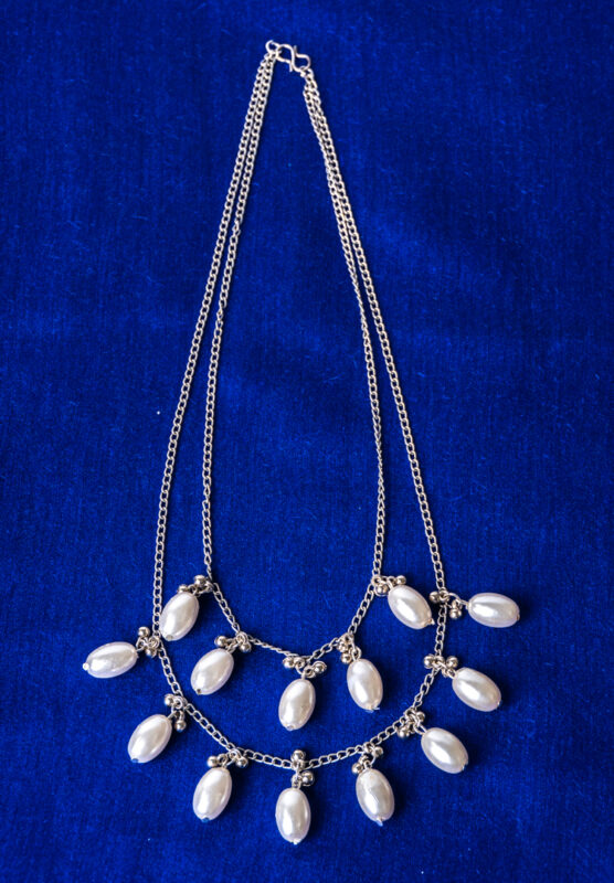 Chic double-layered curb chain necklace in a polished silver-tone finish, styled with oval pearls and small circular beads, complete with an S-hook closure.