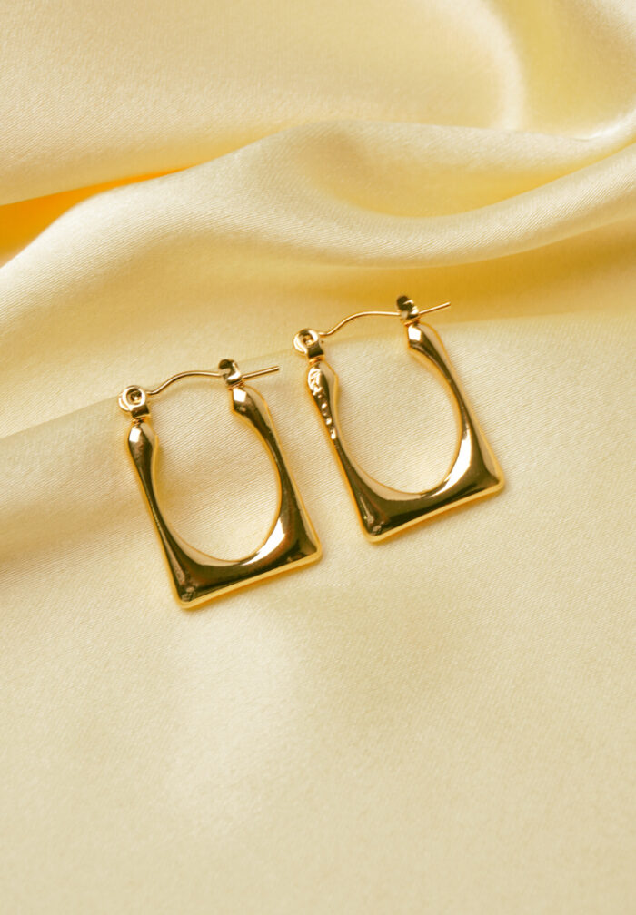 Timeless and sophisticated open-end rectangular metal hoop earrings with a high-shine gold-tone finish and a classic hinged back closure