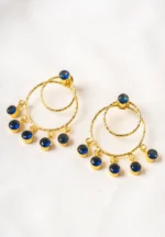 Trendy gold-tone/navy blue hoop earring with a hammered finish, layered hoop design, blue dangling circular beads, and a striking blue stone on top, fastened with a push-back closure.