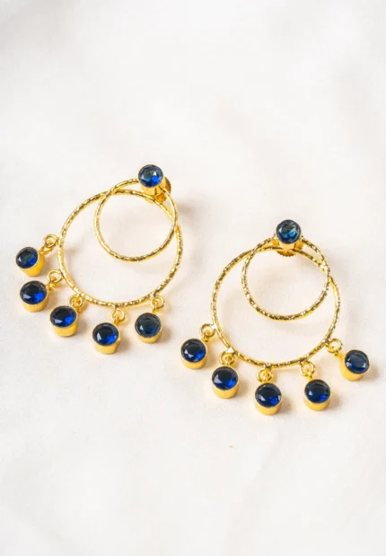 Trendy gold-tone/navy blue hoop earring with a hammered finish, layered hoop design, blue dangling circular beads, and a striking blue stone on top, fastened with a push-back closure.