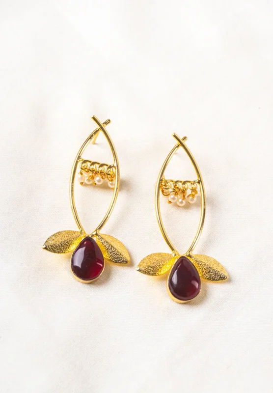 Charming oxidized silver-tone floral dangling earring with delicate detailing, red-colored teadrop shaped stones, two- textured leaves at the bottom, and a push-back post for a secure fit.
