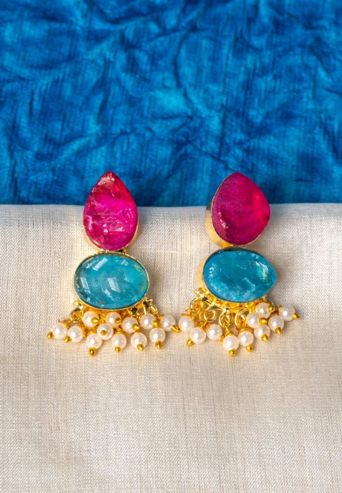 Chic teardrop-shaped metal drop earrings with a gold/aqua blue finish, showcasing a raw gemstone in an blue colored oval shaped druzy with series of a small pearl beads, and a push back closure.