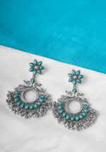 Metal dangle earring with oxidised silver tone finish featuring bird shaped design with flower shaped top designed with turquoise coloured teardrop shaped stones and ghungroos with a curved hook closure