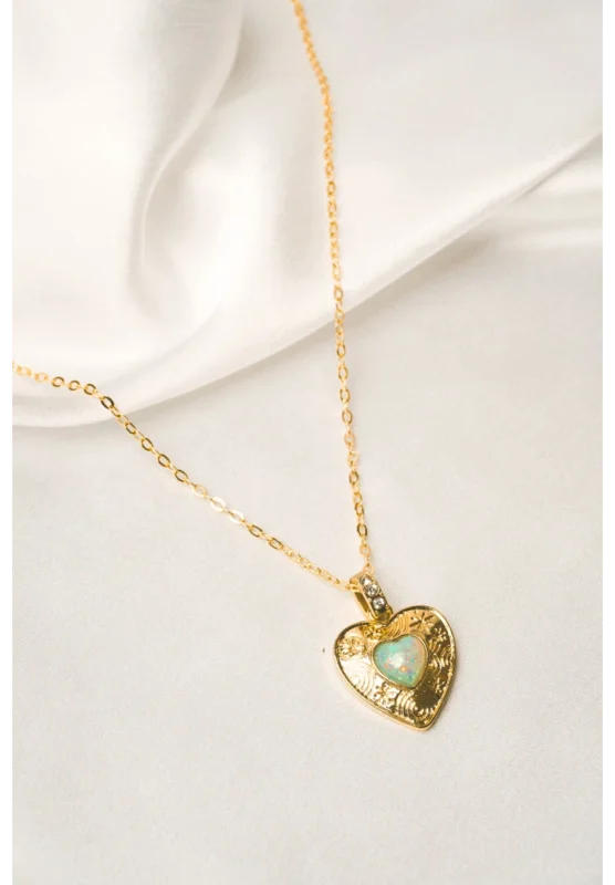 Stylish gold-tone necklace with a filled flat cable chain, an elegant heart pendant,with delicate filigree and a light opal blue stone in the center and a lobster claw clasp.