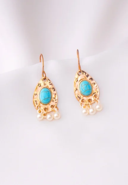 Sophisticated metal teardrop drop earring with a hammered texture, gold-tone/turquoise, pearl white finish, embellished with a turquoise stone in the center and three acrylic pearl beads at the base, secured with a curved hook.