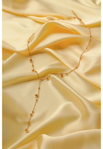 Sophisticated gold-tone lariat necklace with a satellite chain structure, round bead accents, and a secure lobster clasp closure.