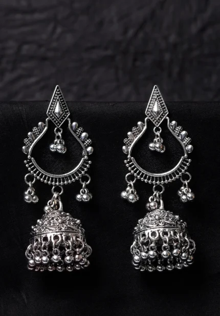 Oxidised jhumka earrings with complex floral detailing, featuring a finely detailed teardrop-shaped top, dangling circular beads, and ghungroos at the bottom, secured with a push-back closure.