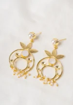 Delicately designed floral metal dangle earrings with a polished golden tone and pearl white finish, featuring a circular pearl centerpiece, small pearl bead accents at the bottom, and a circular pearl top with a push-back closure.