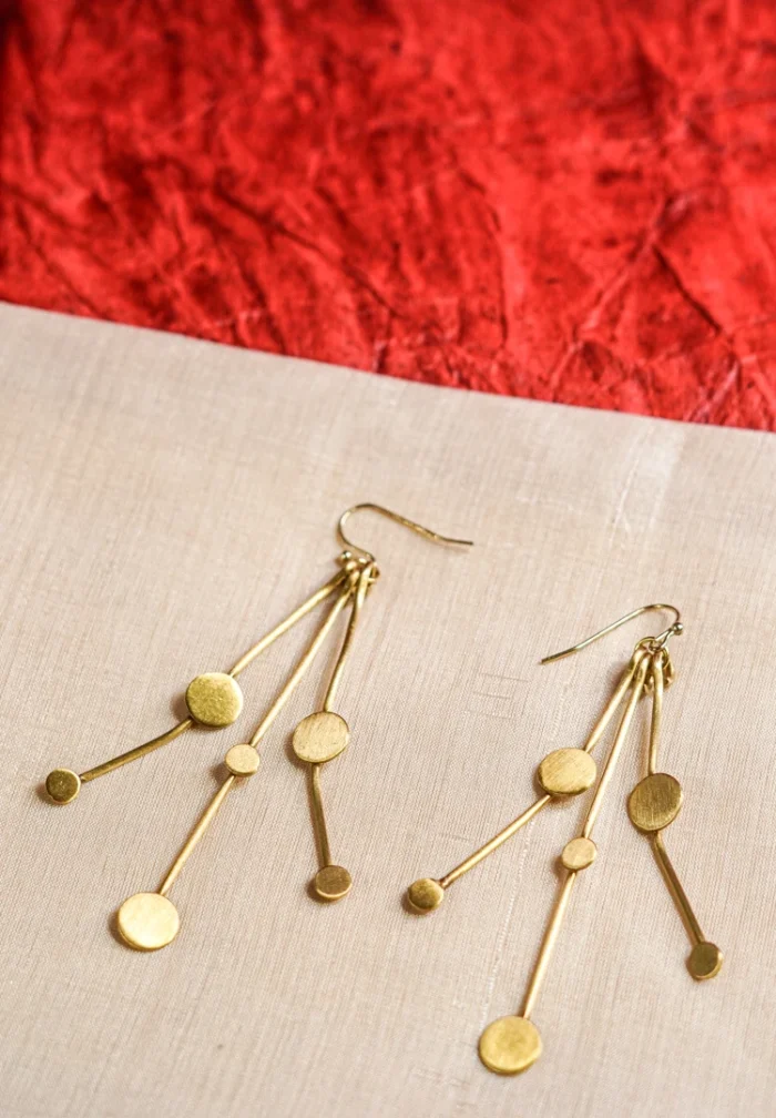 Chic geometric brass earrings with a lightweight design, featuring three slinging stem-like wires adorned with evenly spaced circular discs, secured with a French hook.