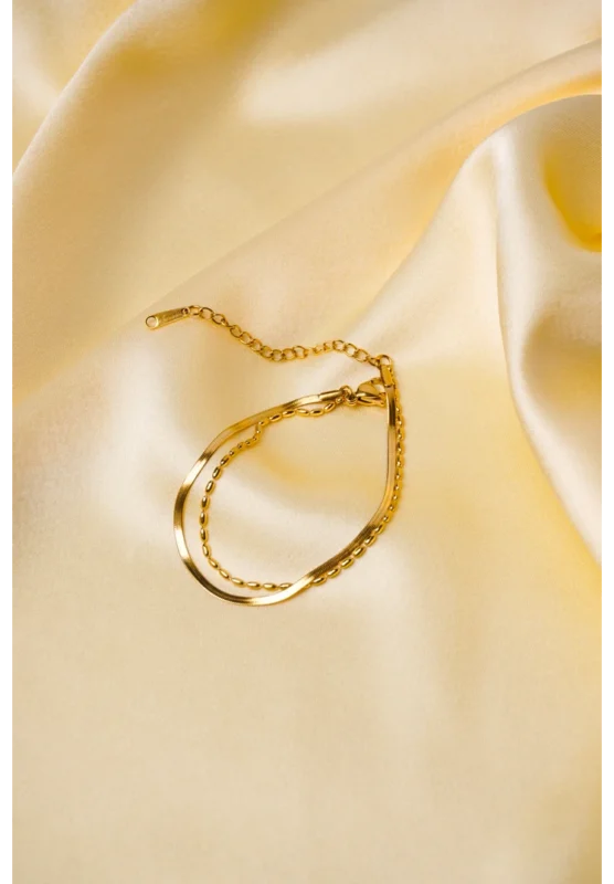 Elegant adjustable curb chain bracelet in a gold-tone finish, featuring a curved metallic wire centerpiece with a dangling spherical charm and a secure spring ring clasp.