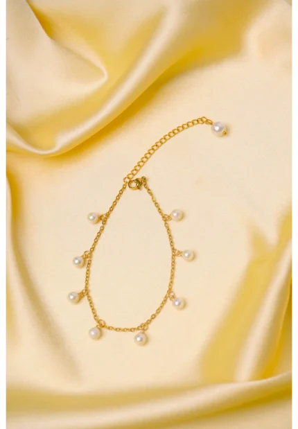 Elegant adjustable curb chain bracelet in a gold-tone finish, featuring a curved metallic wire centerpiece with a dangling spherical charm and a secure spring ring clasp.