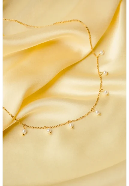 Elegant adjustable curb chain bracelet in a gold-tone finish, featuring a curved metallic wire centerpiece with a dangling spherical charm and a secure spring ring clasp.