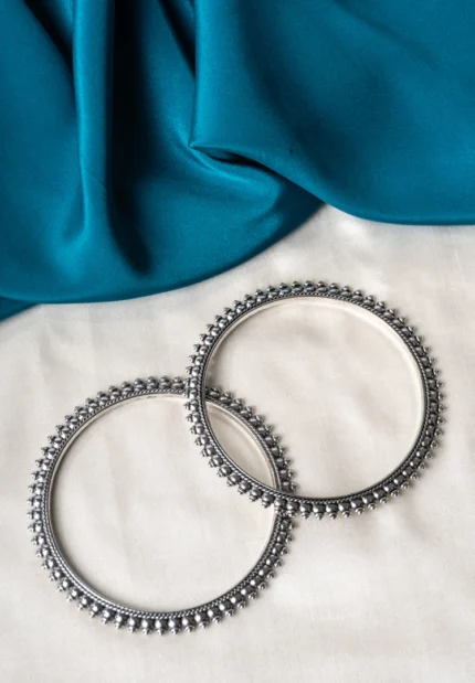 Antique-inspired oxidized silver-tone bangle set with finely detailed lines and circular metallic beaded designs.