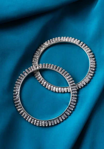 Antique-inspired oxidized silver-tone bangle set with cylindrical patterns with fine delicate detailing.