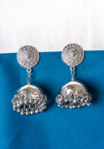 Oxidized silver-tone metal drop earring featuring a circular top with intricate floral detailing, attached to a jhumka adorned with ghungroos at the bottom, secured with a push-back closure.