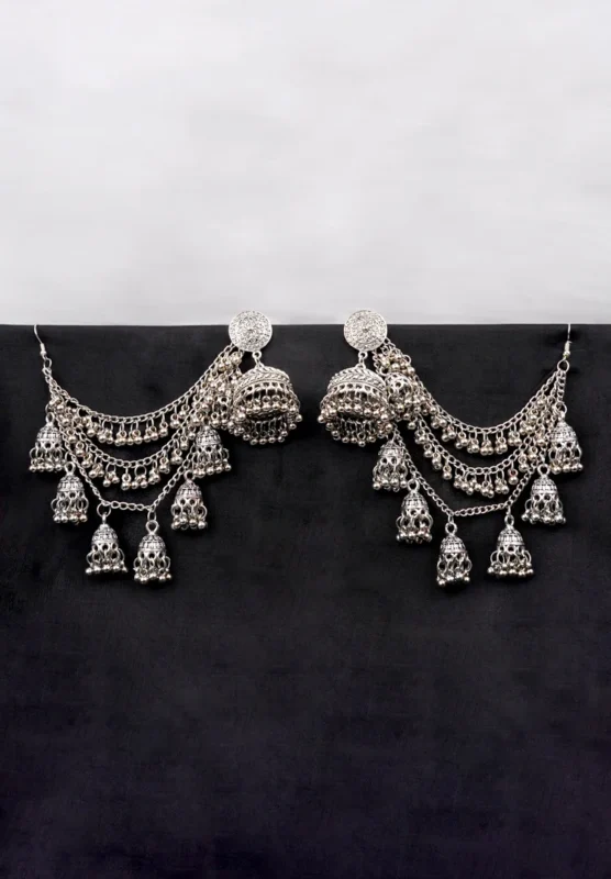 Antique-style silver-tone jhumka ear hair chain earring featuring a floral-detailed circular top, cascading chain tassels with ghungroos and miniature jhumkas, finished with a push-back and French hook closure.