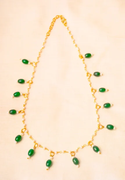 Timeless gold-tone metal necklace with interconnected pearl beads, enhanced with oval-shaped details and a secure S-hook closure.