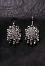 Statement oxidized silver floral drop earring showcasing fine detailing, dangling ghungroos, and a secure French hook closure