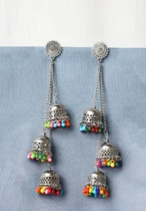 Metal dangle earring with oxidised silver tone finish featuring detailed circular top with graduated jhumkas and colorful beads at the edges with a french hook closure.