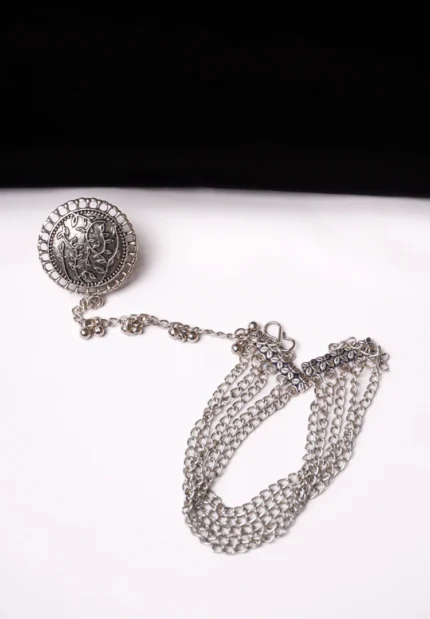 Elegant oxidised silver-tone bracelet with a ring design, adorned with fine delicate floral detailing with chain tassels and finished with an S-hook closure.