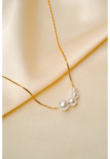 Minimalist hayseed chain necklace with a gold-tone finish, showcasing five lustrous graduated pearl beads and a lobster claw closure.